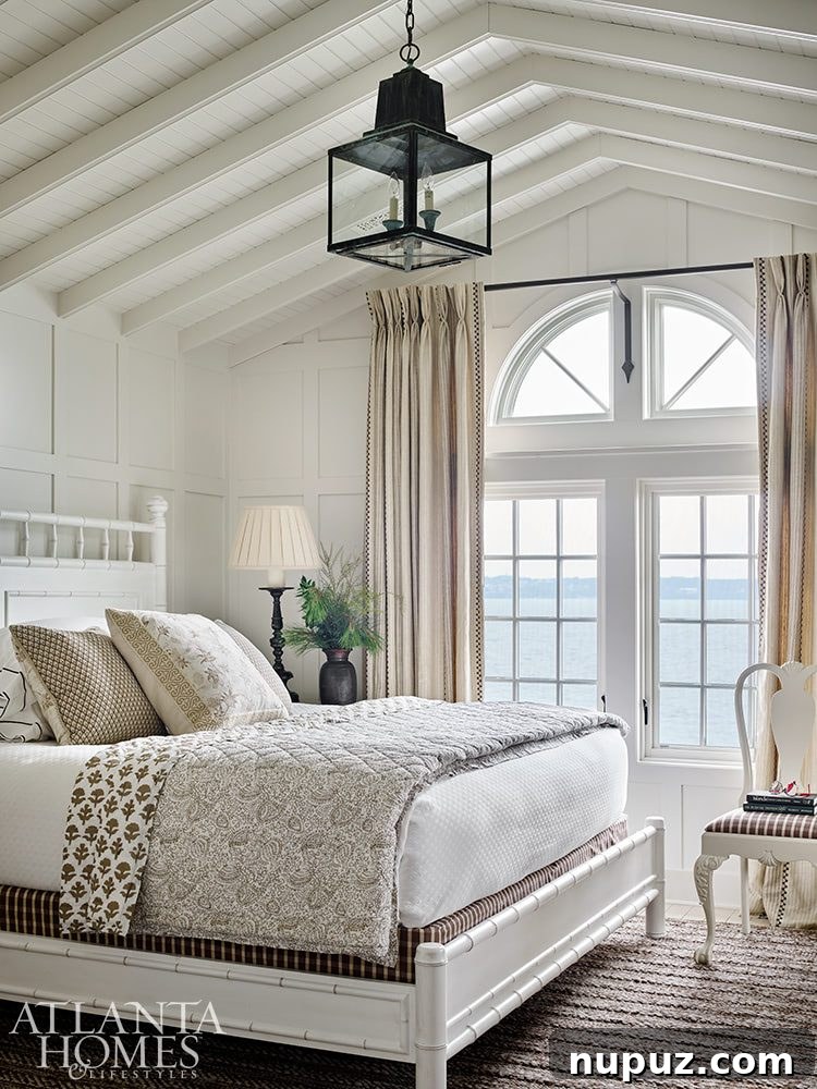 Elegance Meets the Water's Edge: A Jackye Lanham Home 15 A spacious and brightly lit living room with large windows overlooking a scenic view, furnished with comfortable sofas and elegant decor.