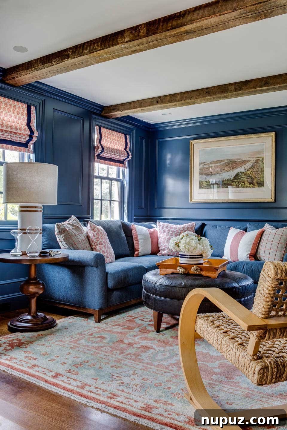 Living room with sectional sofa, leather ottoman, and wood beams in Chatham beach house