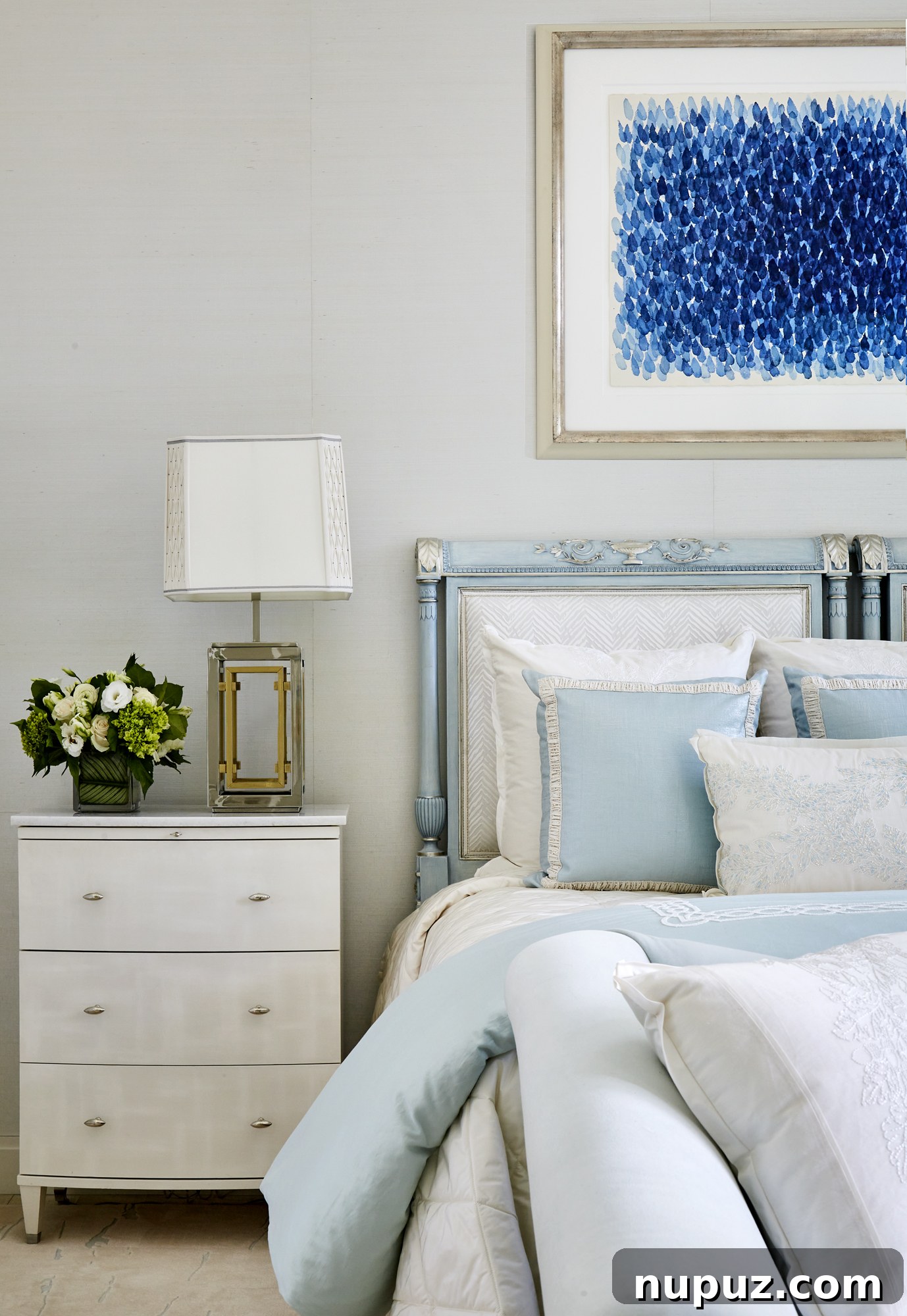 Inside a Palm Beach Home Redefining Modern Elegance 11 Serene blue and white bedroom featuring striking modern art above the bed, bespoke textiles, and a tranquil atmosphere in the Palm Beach estate.
