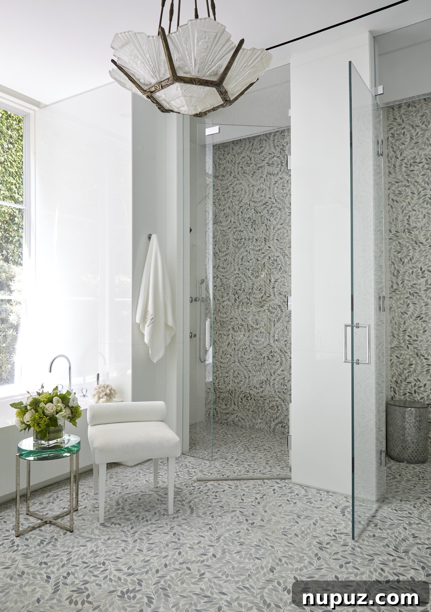 Inside a Palm Beach Home Redefining Modern Elegance 12 Luxurious bathroom featuring seamless glass shower doors, a magnificent statement chandelier, and elegant blue and white tile work for a truly unique space.