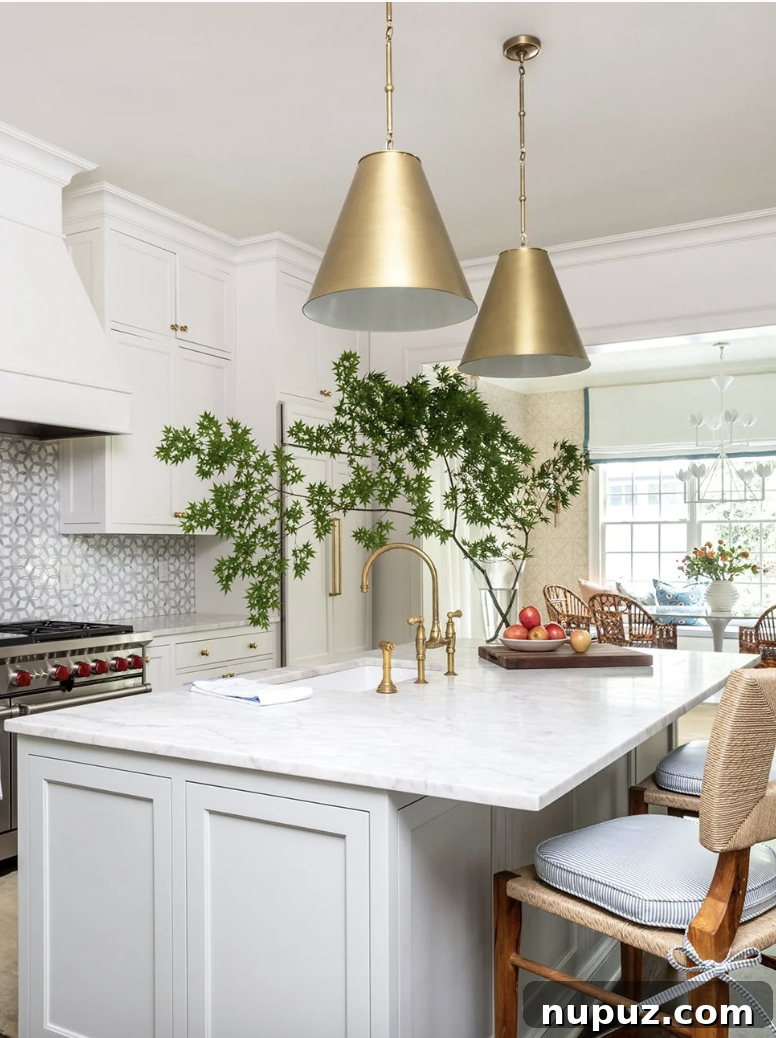10 Breathtaking Kitchen Makeovers to Inspire You 4 Elegant white kitchen with stunning dark countertops, natural wood flooring, and large windows offering abundant light, blending classic style with modern appeal.