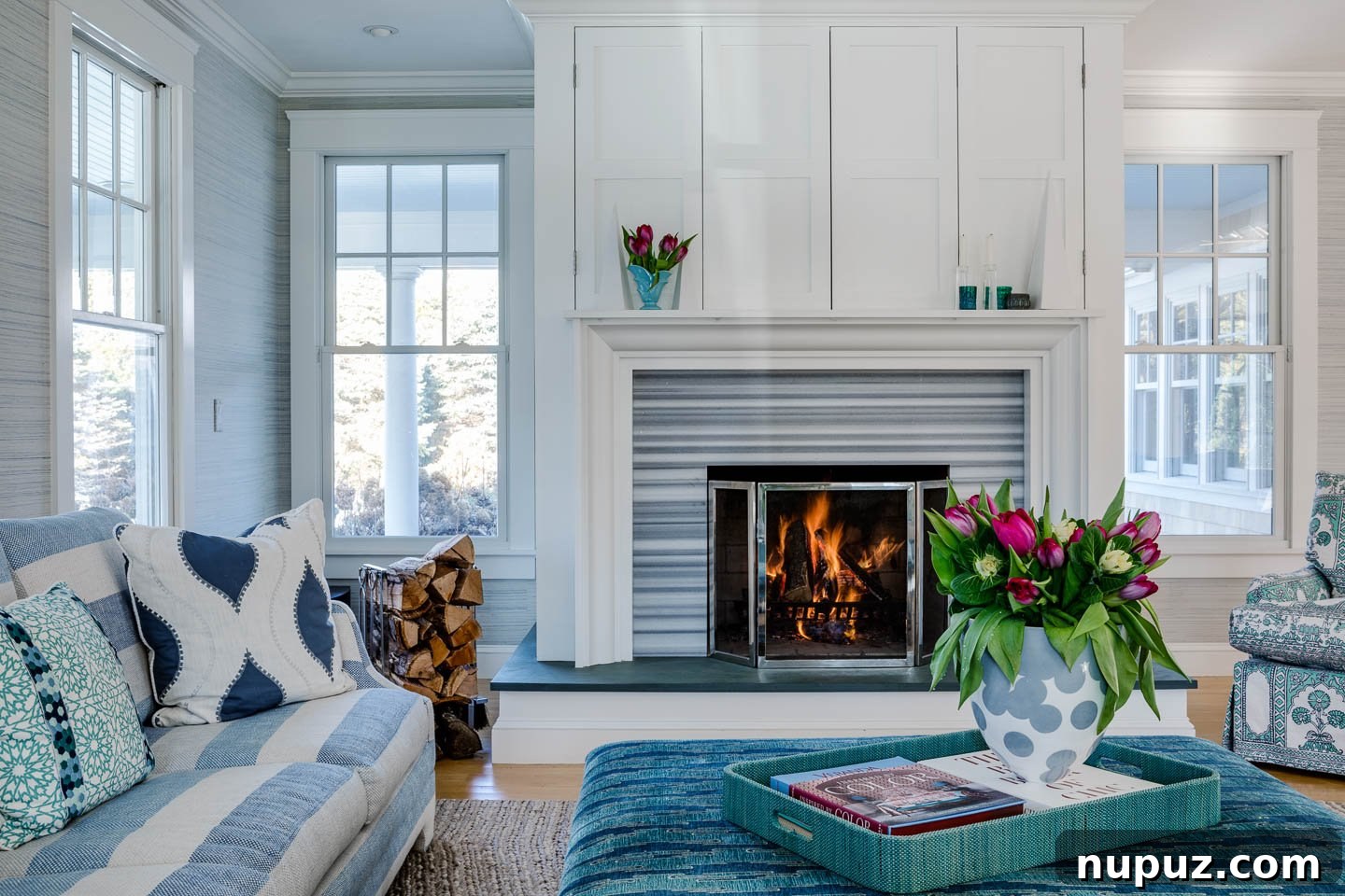 Blue and white coastal living room featuring a stylish fireplace and elegant decor by Digs Design Company
