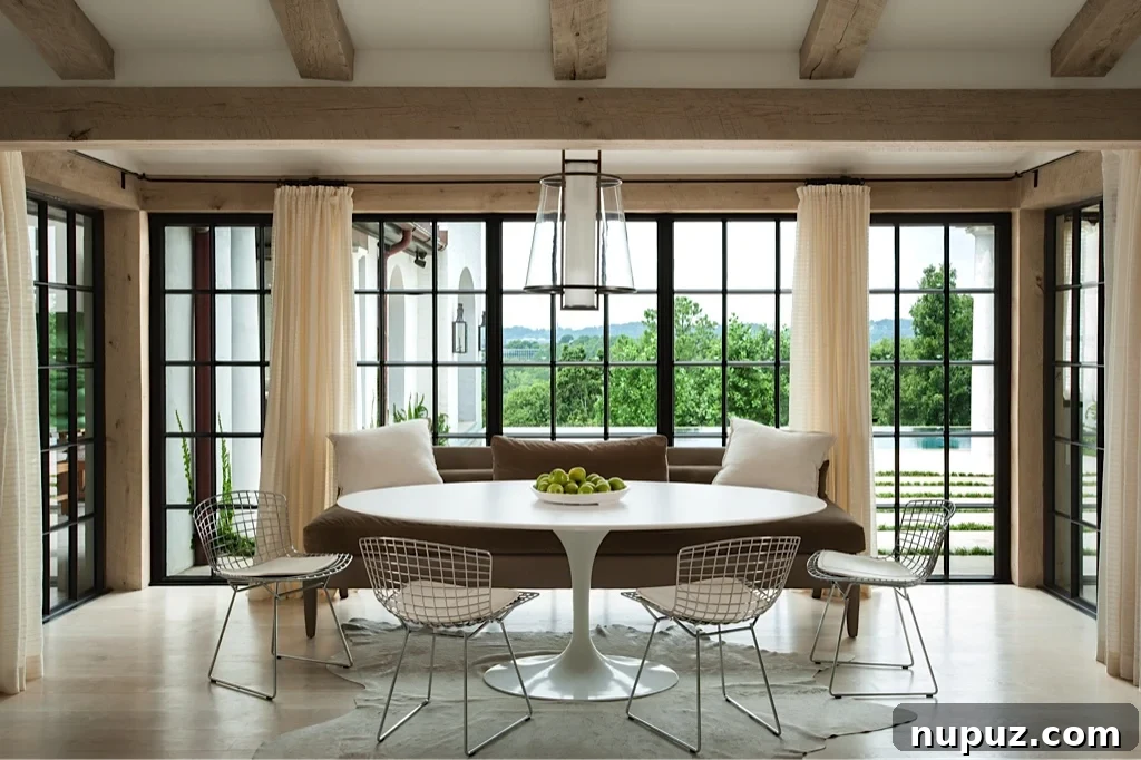 Elegant dining room designed by Paul Bates Architect and Patti Woods Interiors, featuring blonde wood elements, an oval Saarinen dining table, and striking blonde wood beams.