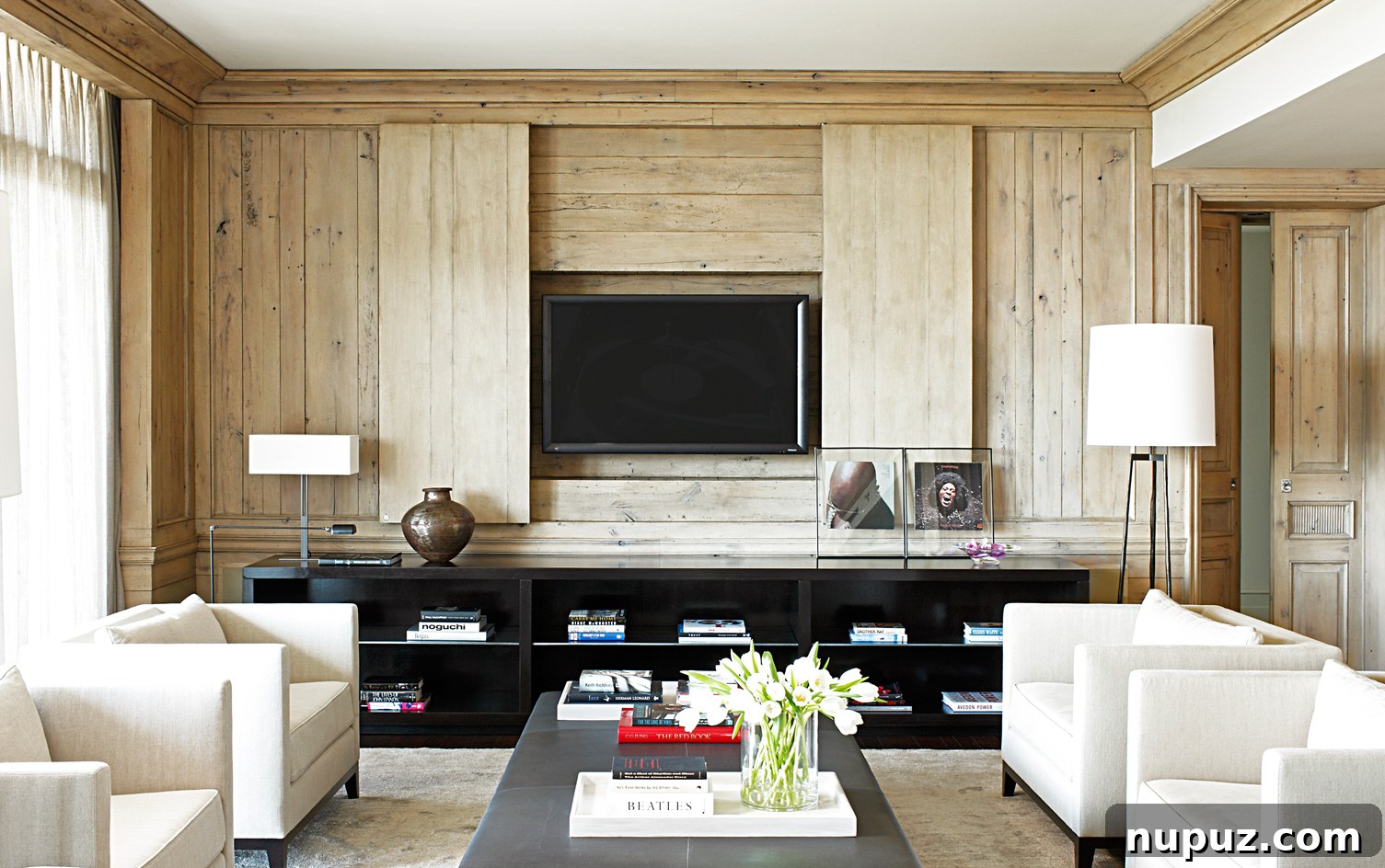 Luxurious living room featuring neutral decor and elegant blonde wood paneling, a signature look by Paul Bates Architecture and Betsy Brown Interiors.