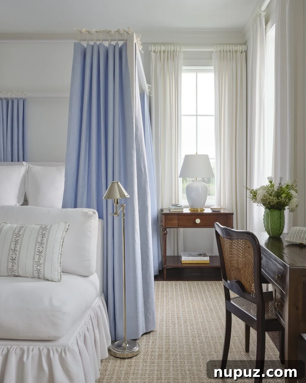 Kara Miller's Farmhouse Retreat 11 Elegant blue and white bedroom featuring a stunning canopy bed with delicate drapery, a signature touch in Kara Miller's sophisticated farmhouse designs. Photography by Brantley Photography.