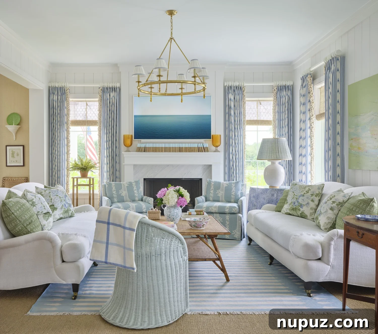 Kara Miller's Farmhouse Retreat 3 Bright and spacious living room in Kara Miller's farmhouse, featuring comfortable seating, a grand stone fireplace, and abundant natural light filtering through large windows. Photography by Brantley Photography.