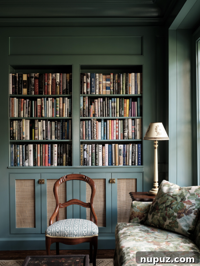 Dramatic and sophisticated living area with built-in bookshelves in a moody, rich color, a hallmark of Stephanie Sabbe's ability to create cozy yet elegant spaces, perfect for reading and relaxation.