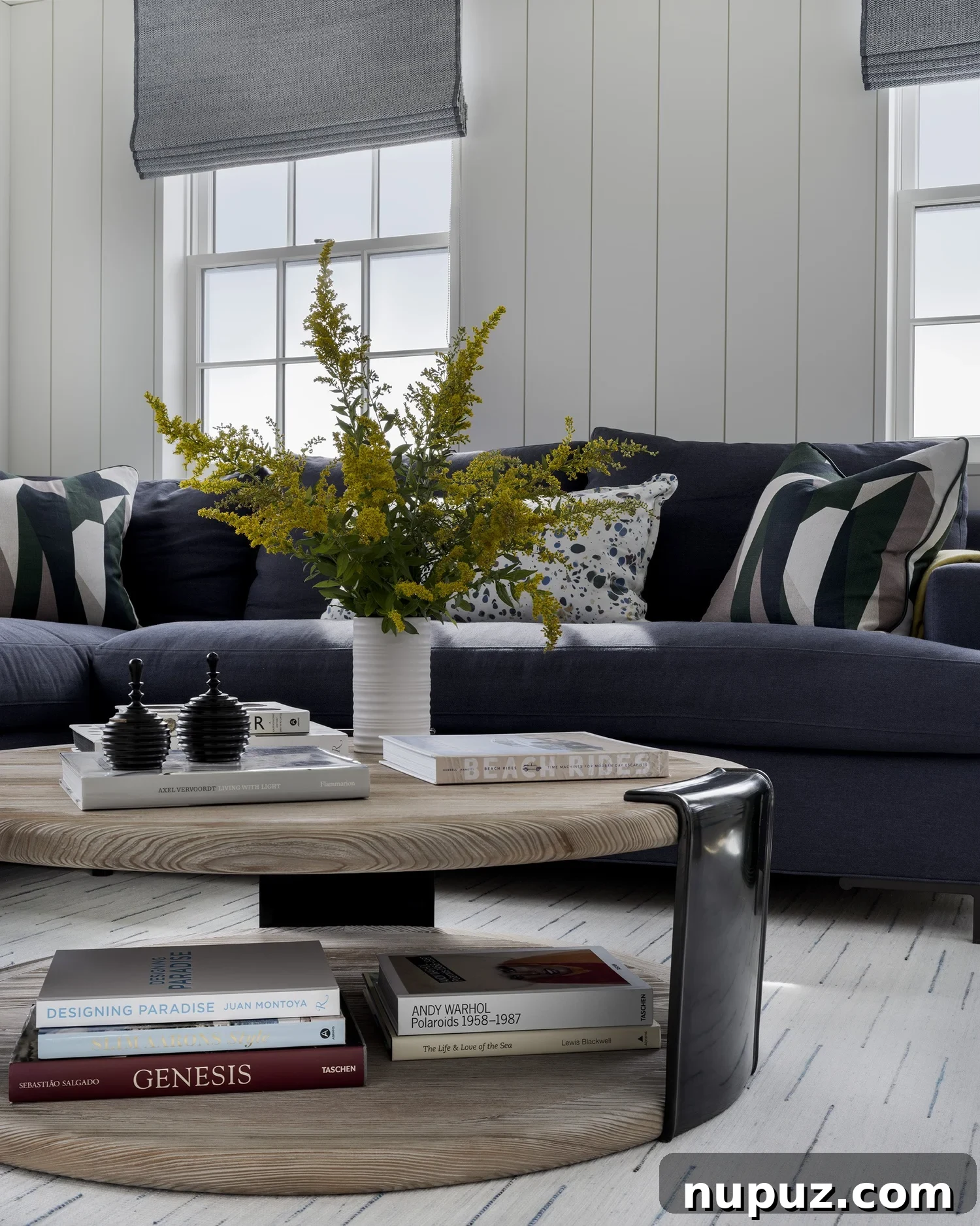 Nantucket's Timeless Coastal Sanctuary Unveiled 6 Cozy living room featuring a navy blue sectional sofa against white paneled walls, ideal for relaxation in a coastal home