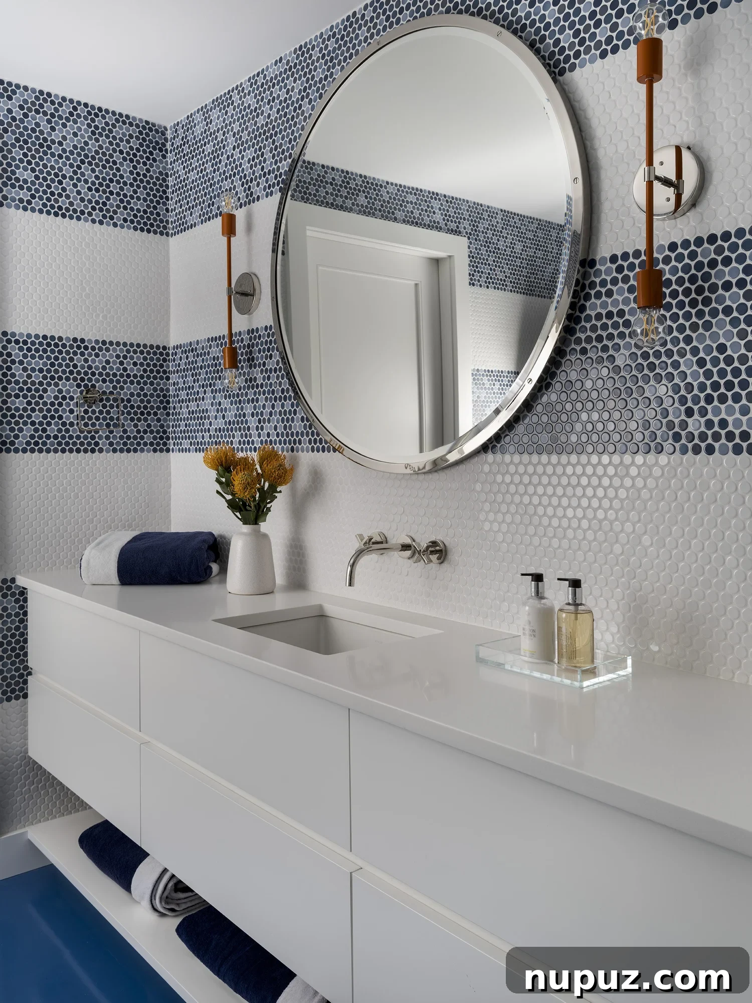 Nantucket's Timeless Coastal Sanctuary Unveiled 9 Modern coastal bathroom with a chic round mirror and refreshing blue and white tiled shower, designed for serenity