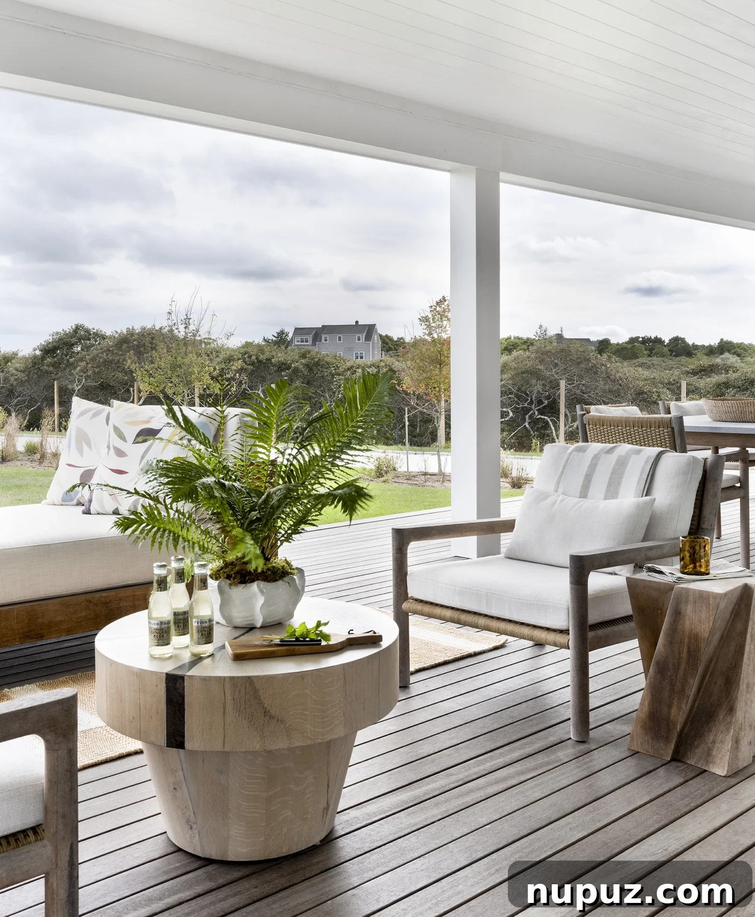 Nantucket's Timeless Coastal Sanctuary Unveiled 10 Inviting covered porch with classic white outdoor furniture, perfect for relaxing and entertaining in a coastal setting