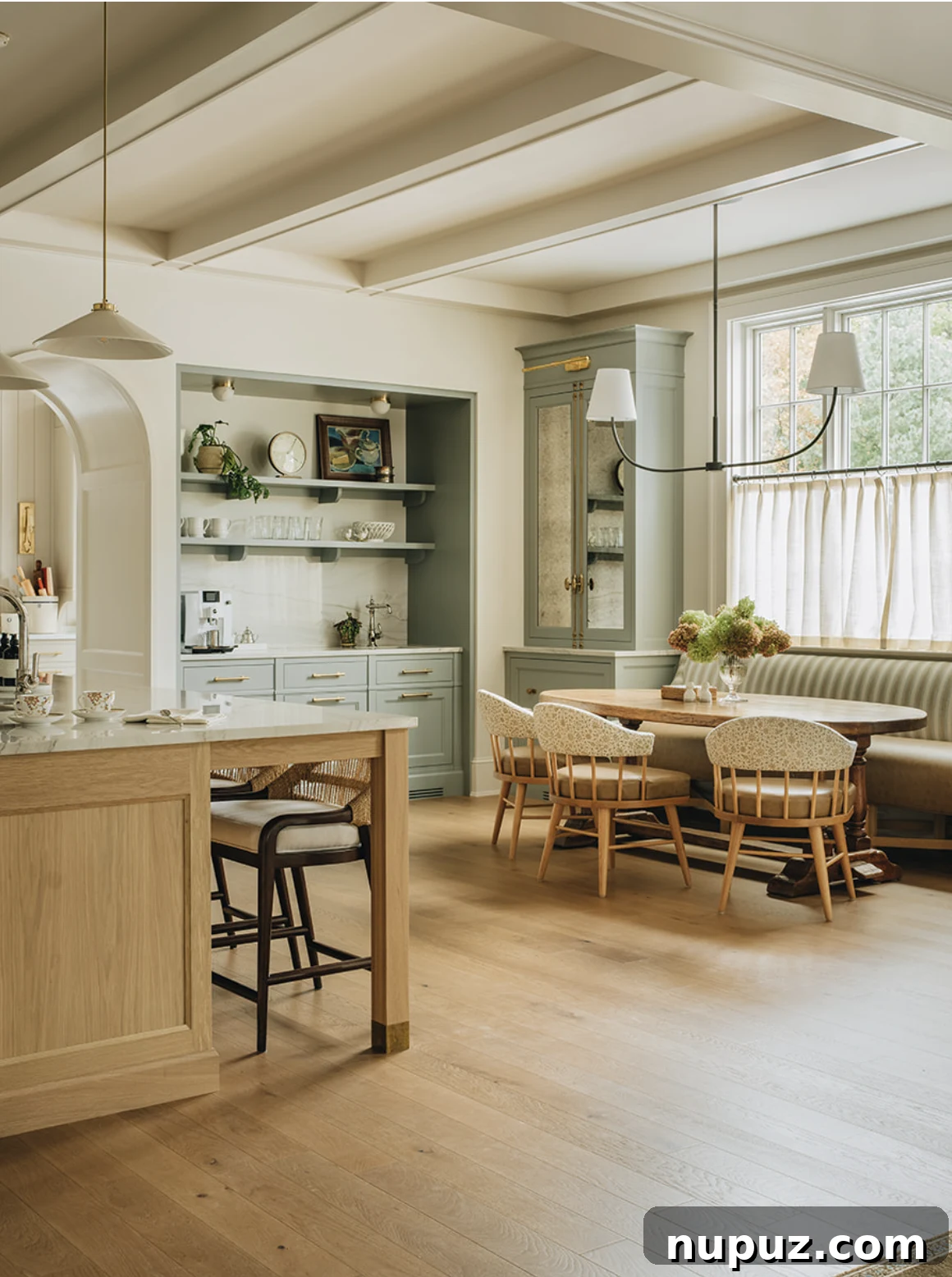 Infuse Your Space with Soul: Creative Home Decor Inspirations 12 Open-concept kitchen with exposed wooden beams, a prominent blonde wood island, and ample natural light, highlighting a blend of modern and traditional elements.