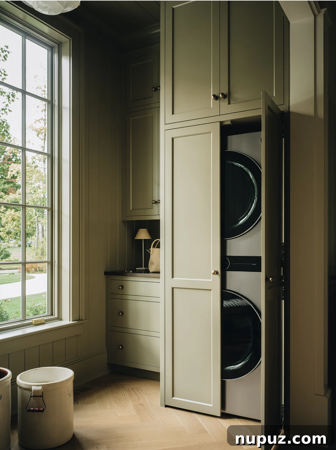 Infuse Your Space with Soul: Creative Home Decor Inspirations 15 Efficient and stylish laundry room featuring attractive green built-in cabinets, a spacious countertop, and modern appliances, making chores a pleasure.