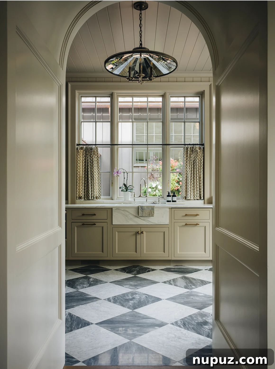 Infuse Your Space with Soul: Creative Home Decor Inspirations 8 Grand archway leading into a beautifully appointed kitchen, featuring a classic farmhouse sink, stylish fixtures, and sophisticated black and white marble floors.