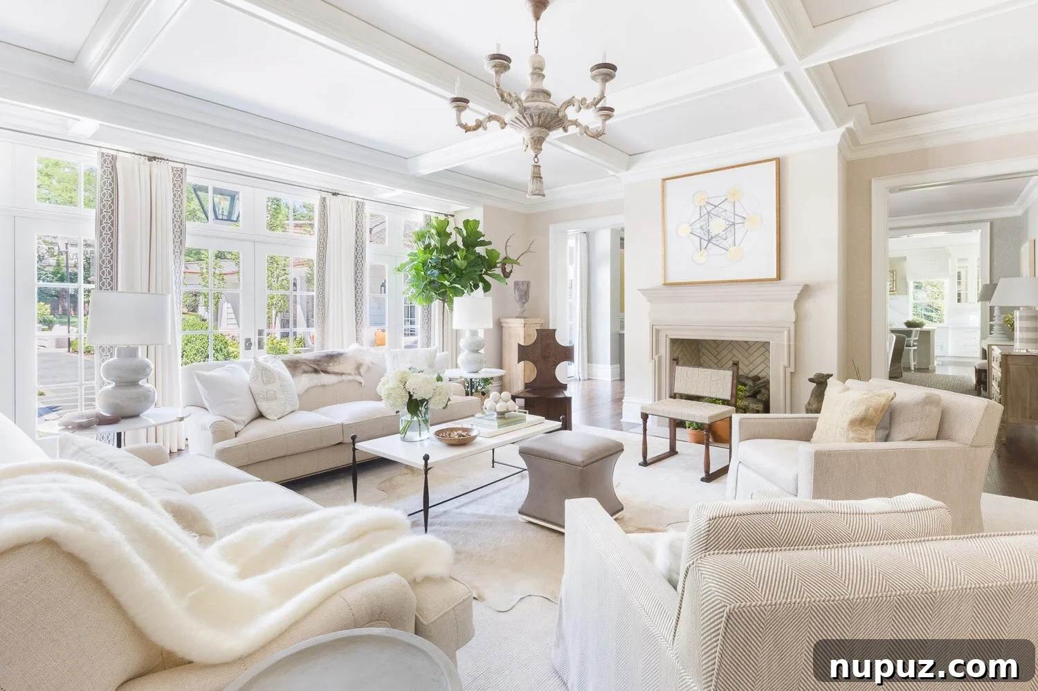 Elegant living room with a neutral color palette, featuring a large sectional sofa, decorative pillows, and a coffee table, illuminated by natural light.