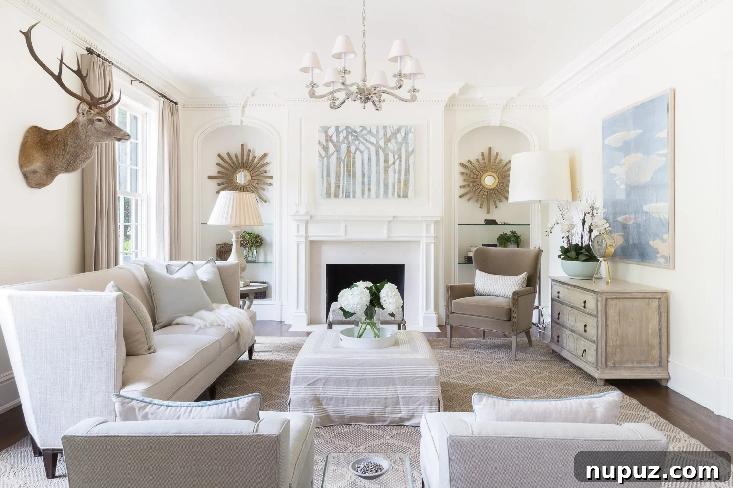Cozy living room featuring a large white sofa, patterned throw pillows, a rustic wooden coffee table, and large windows bringing in ample natural light, all within a neutral decor scheme.