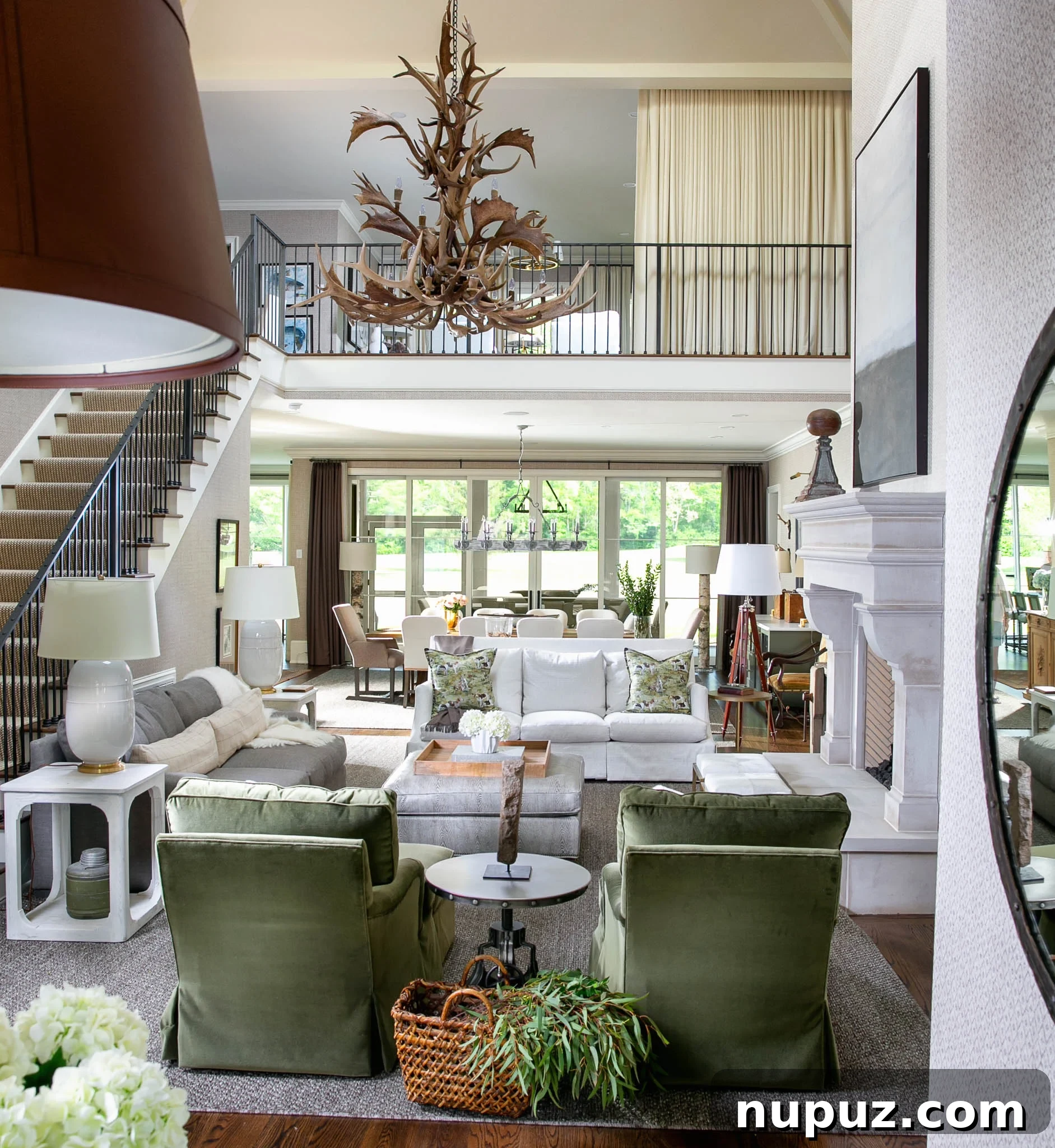 Coastal-inspired living room with a large neutral sofa, patterned throw, a unique round coffee table, and an abundance of natural light from tall windows.