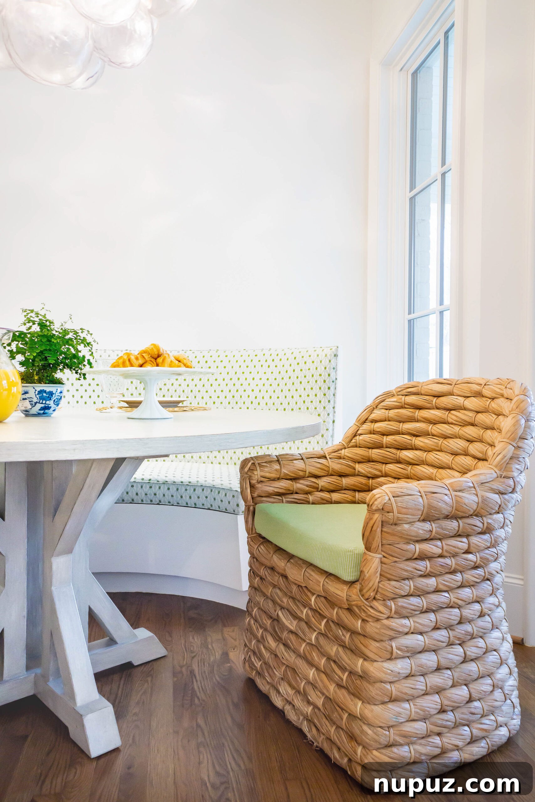 Lindley Arthur's Signature Style: 10 Breathtaking Interiors 4 Emery Davis Photography capturing a Lindley Arthur Interiors breakfast room with a cozy banquette, round table, and inviting seagrass chairs.