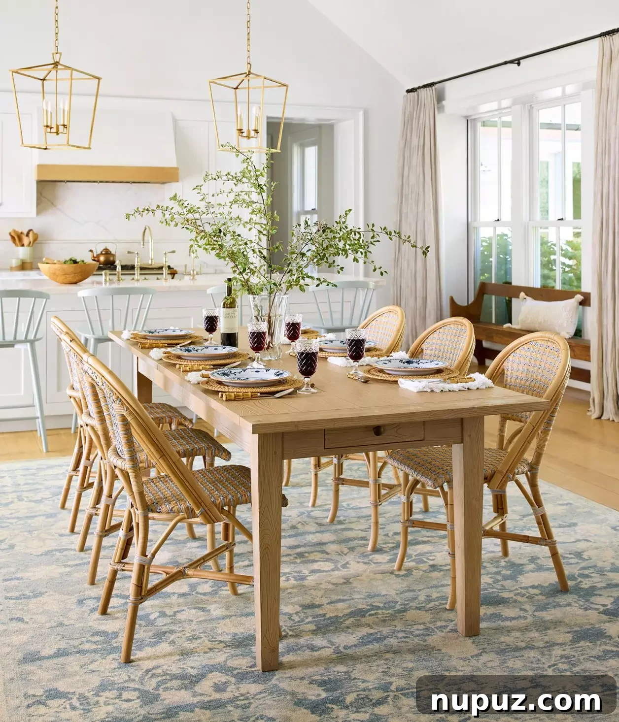 Modern coastal kitchen featuring Serena & Lily wicker bar stools with white countertops and light cabinetry, adding natural texture.