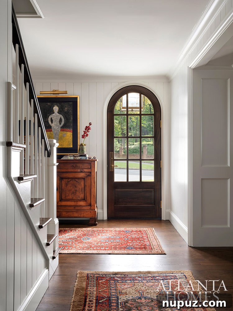 A grand entrance hall with soaring ceilings and a sweeping staircase, hinting at the sophisticated design within this Atlanta residence.