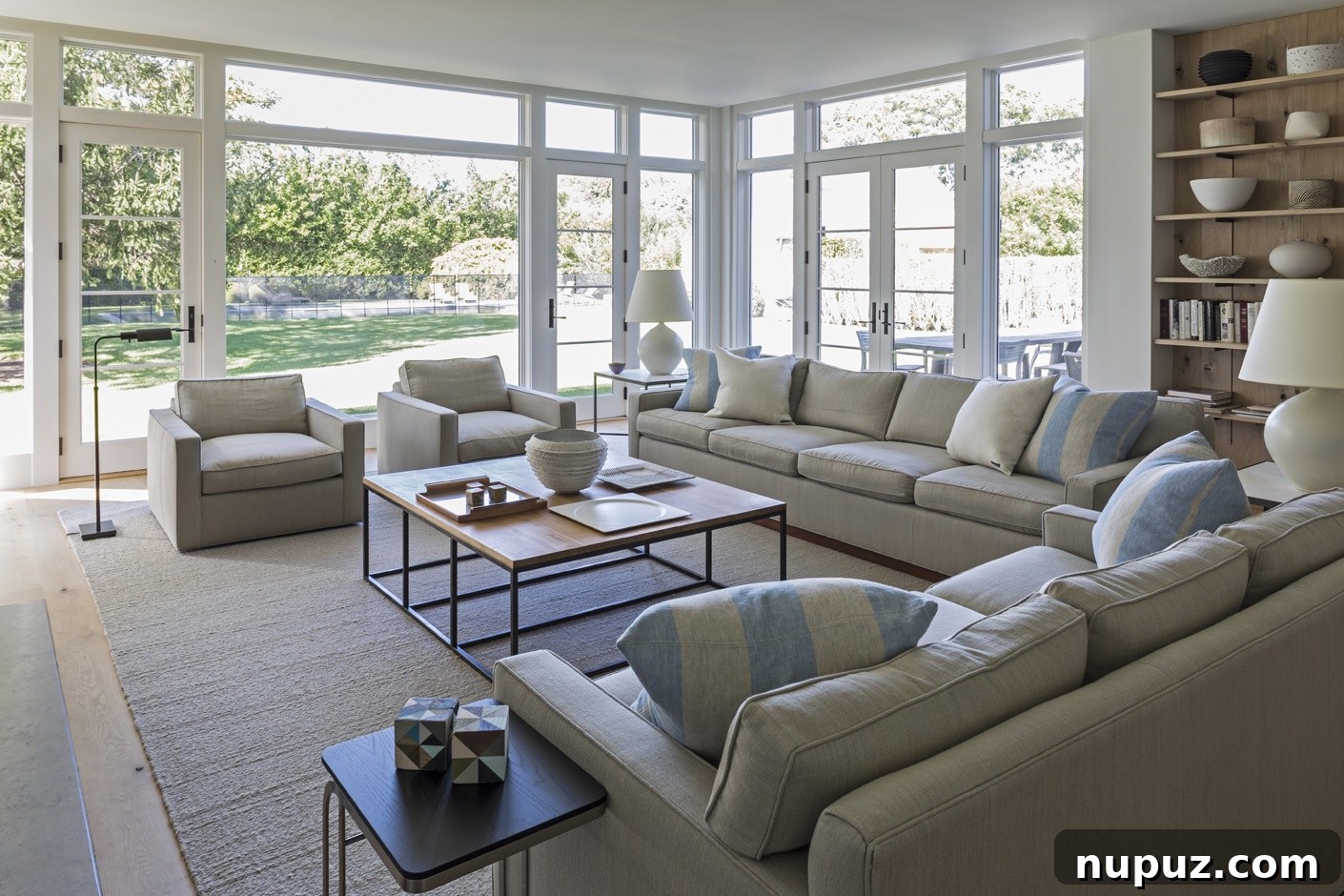Contemporary living room with thoughtfully integrated storage solutions, chic lighting fixtures, and comfortable seating, all part of a cohesive design by Brady Design. Marco Ricca Photography.