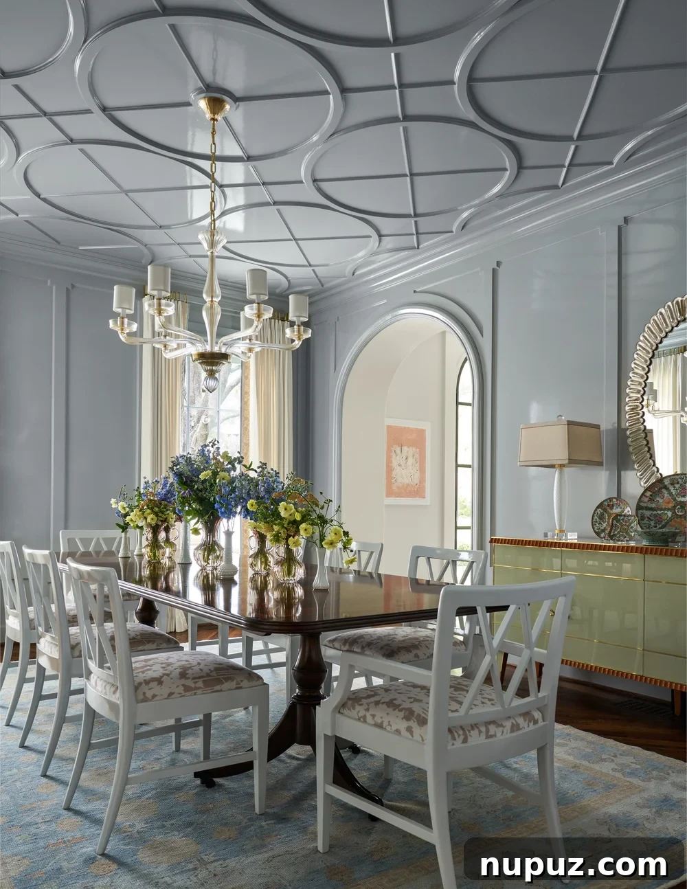 10 Exquisite Dining Rooms by Mary Beth Wagner 10 A refined dining room with a large wooden table, light-colored chairs, and a beautiful rug, showcasing Mary Beth Wagner's layered design approach. Photographed by Nathan Schroder.