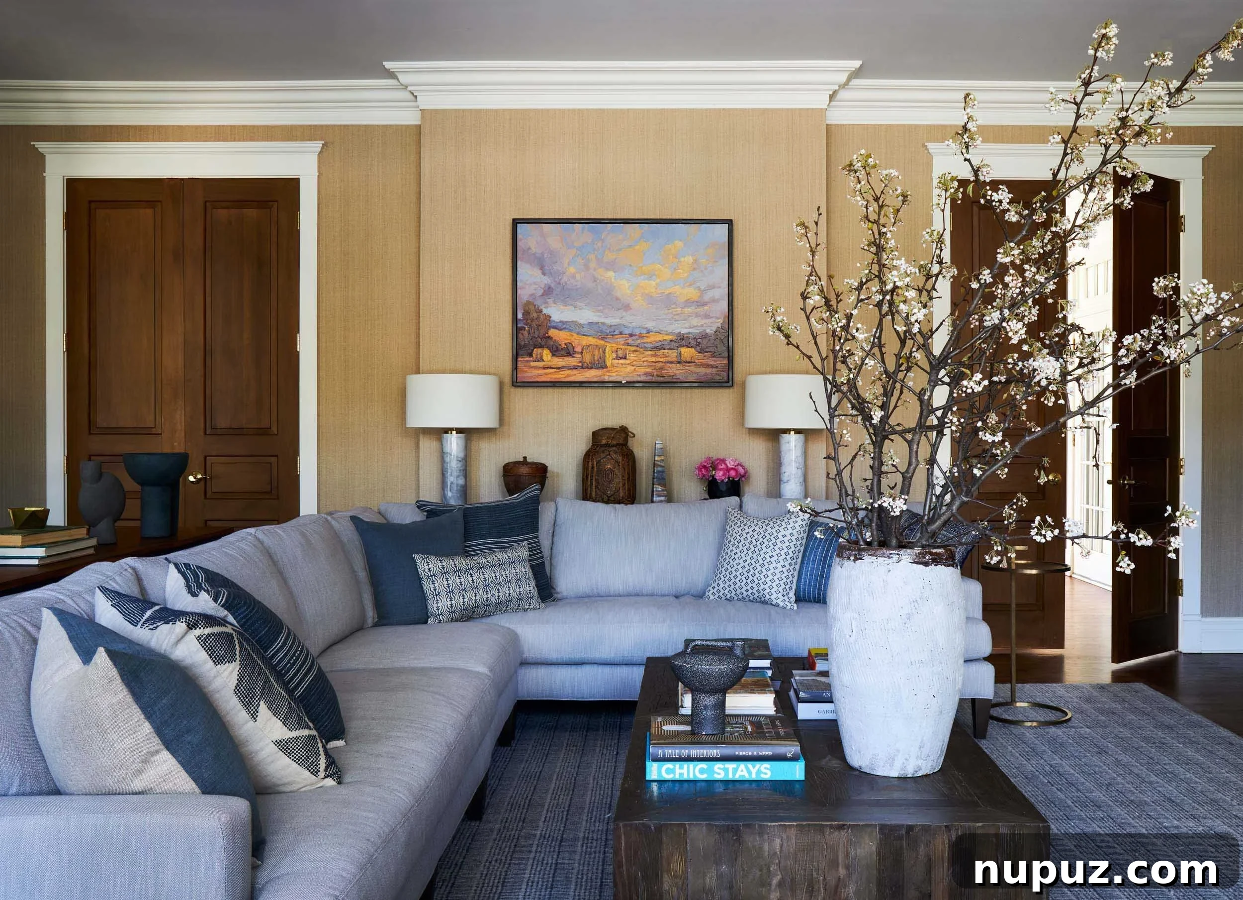 Modern Imparfait Design Studio living room with a large, inviting sofa, contemporary art, and a mix of natural and metallic elements.