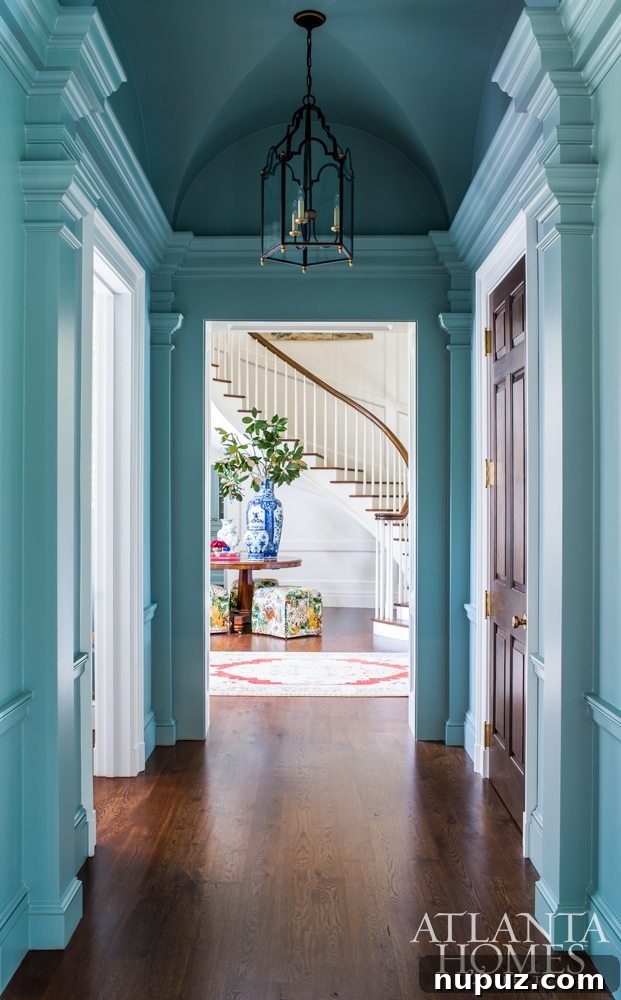 Highlighting architectural details like crown molding, wide baseboards, and paneled walls with strategic paint and lighting enhances a home's inherent soul and craftsmanship. Architect C. Brandon Ingram, Designer Mallory Mathison, Landscape Architect Carson McElheney, Photographed by Jeff Herr.