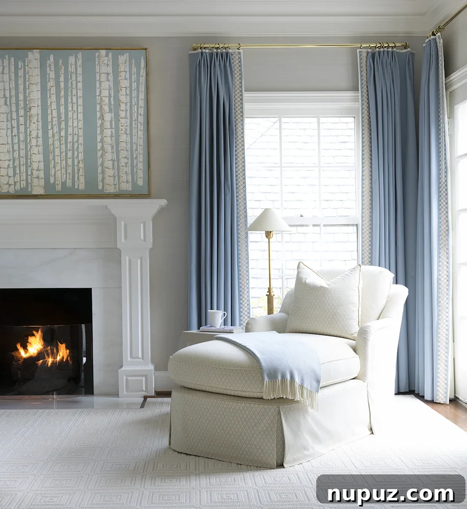 Luxurious blue and white bedroom with a canopy bed, elegant drapes, and a sitting area