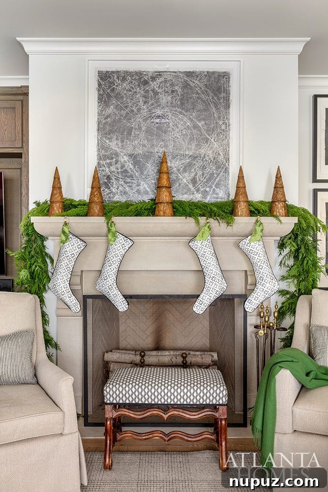 Stunning two-story living room with a tall Christmas tree, grand fireplace, and elegant holiday decor. Design by Huff-Dewberry, Inc.