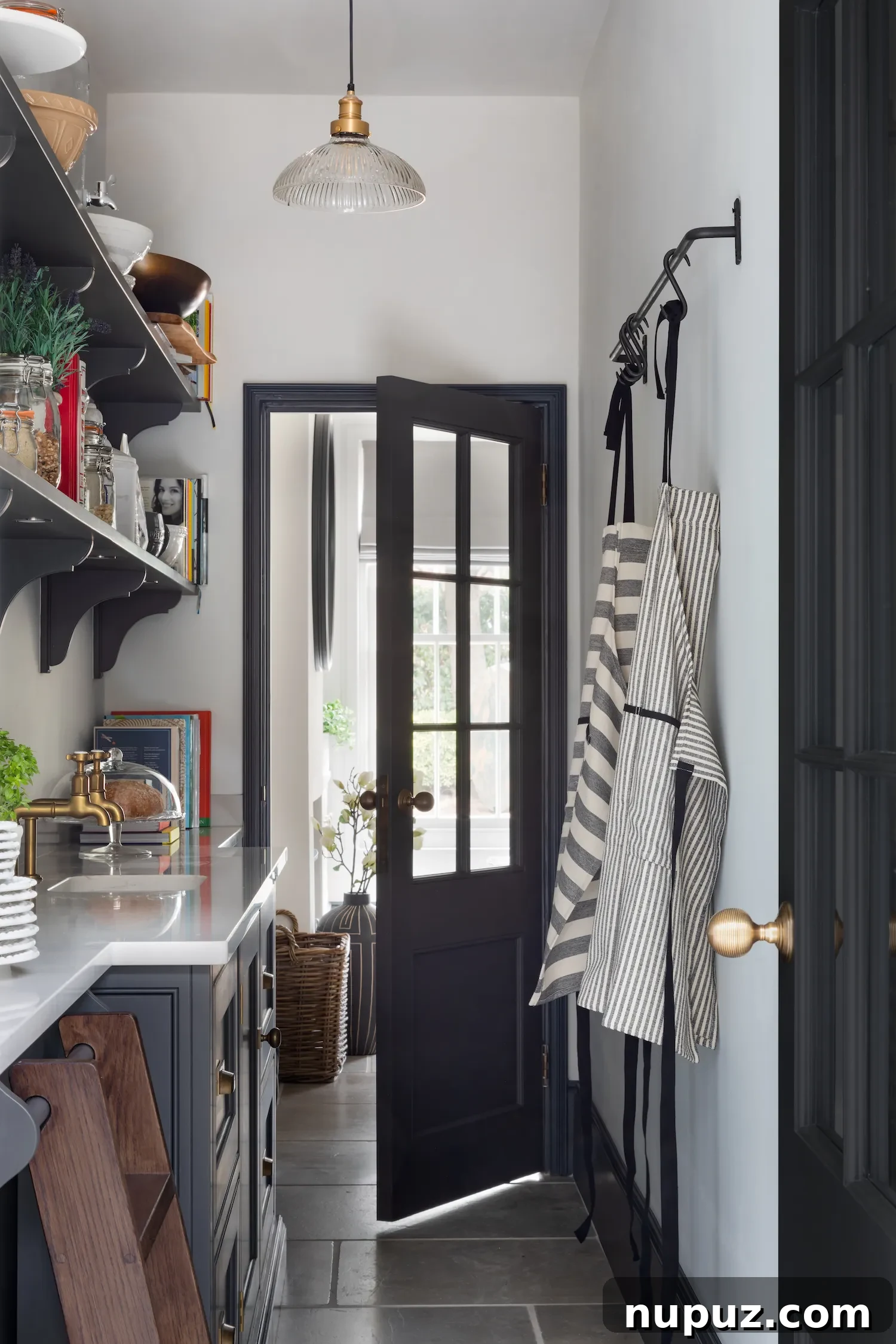Organized kitchen space in a Humphrey Munson design, with a dedicated spot for aprons, by Paul Craig Photography.