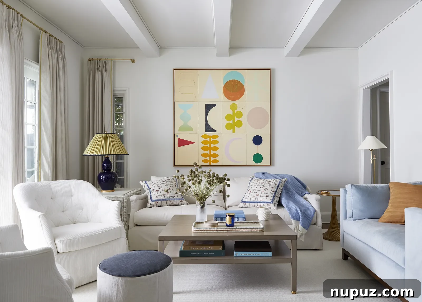 Vibrant living room with blue and white decor, a white chandelier, and colorful abstract art, designed by Georgia Street Design, photographed by Brie Williams.