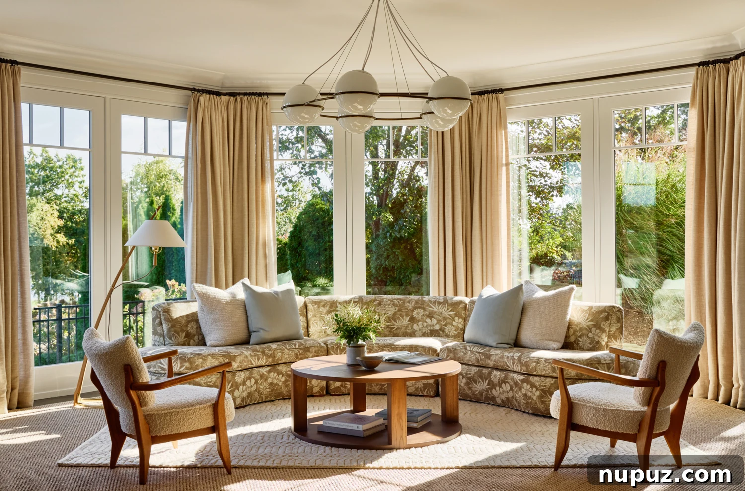 Spacious living room featuring a chic curved sofa in a coastal-inspired blue and white palette.