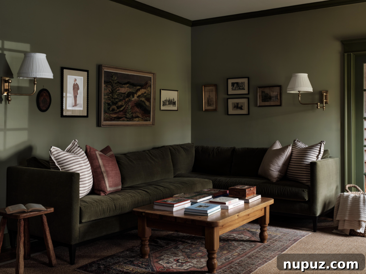 A family room designed by Sabbe Interior Design in Nashville, featuring mossy green walls, comfortable seating, and elegant decor. Photography by Joseph G. Bradshaw.