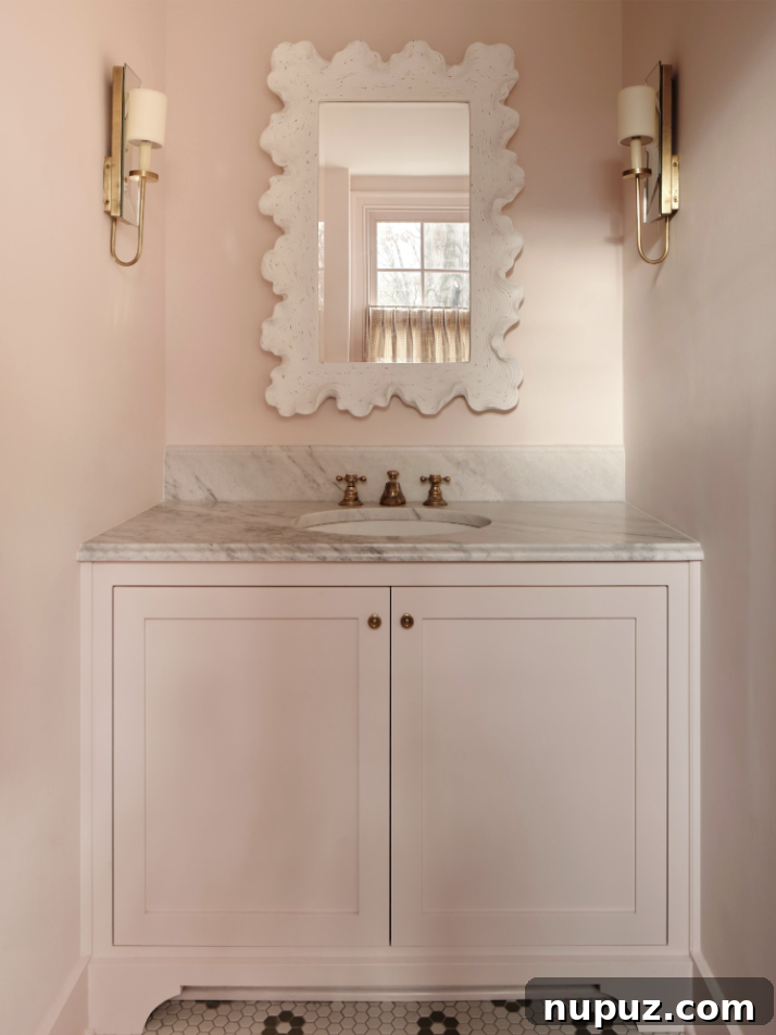The most charming pink bathroom with marble countertops in a Nashville home designed by Sabbe Interior Design. Photography by Joseph G. Bradshaw.