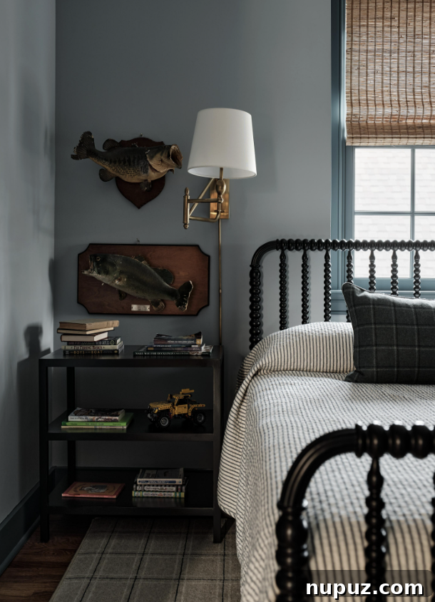 A cozy boy's room in a Nashville home by Sabbe Interior Design, featuring a spindle bed and mounted fish for a playful touch. Photography by Joseph G. Bradshaw.