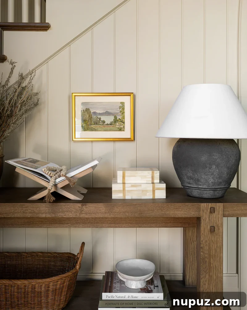 Neutral Reimagined: Beyond White 7 Foyer with a console table and book stand, decorated in warm neutral tones, reflecting a welcoming entrance by Studio McGee.