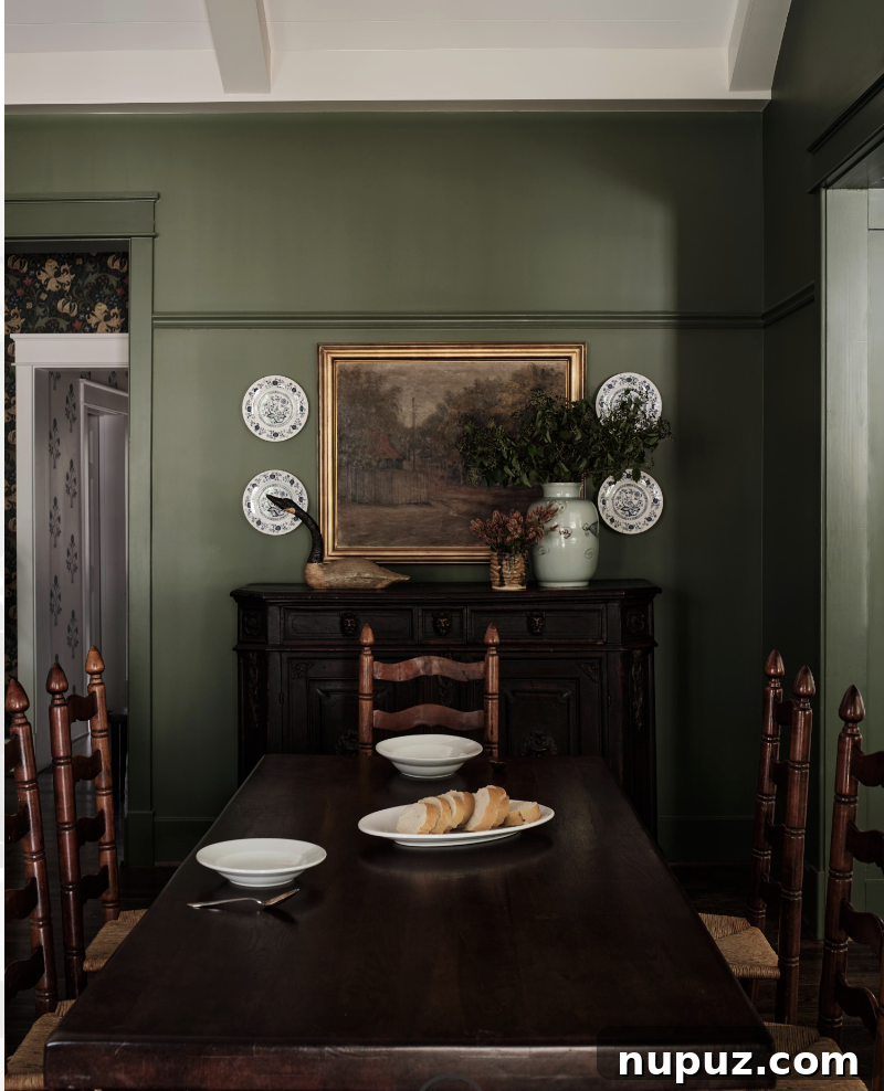 A beautiful green dining room by Sabbe Interior Design, featuring charming antique ladder-back chairs, photographed by Joseph Bradshaw. This space highlights the timeless elegance of purposeful design.