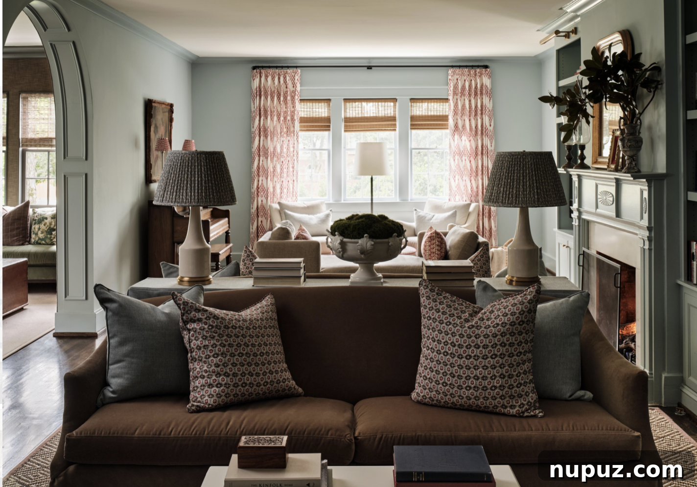 An inviting home library with Visual Comfort brass library lights and beautifully rich, moody blue walls, showcasing the trend of purposeful room design by Sabbe Interior Design. Photographed by Joseph Bradshaw.