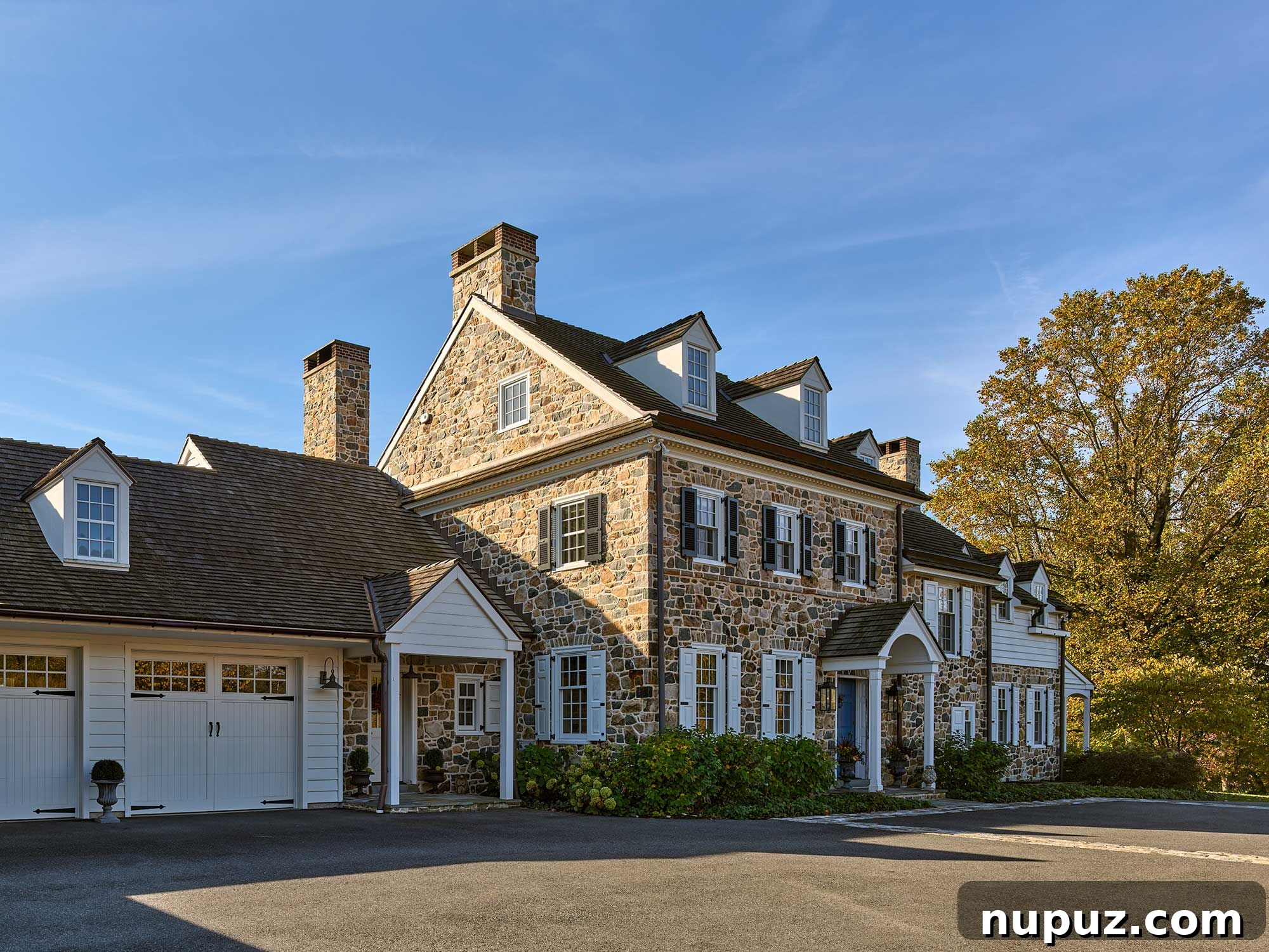 Stately two-story stone home with three dormers, showcasing the exquisite work of Archer & Buchanan Architects. Collaborators include Cushing Custom Homes, Inc. for building, Jonathan Alderson Landscape Architects for landscape design, Barbara Gisel Design for interiors, and Jeffrey Totaro for photography.