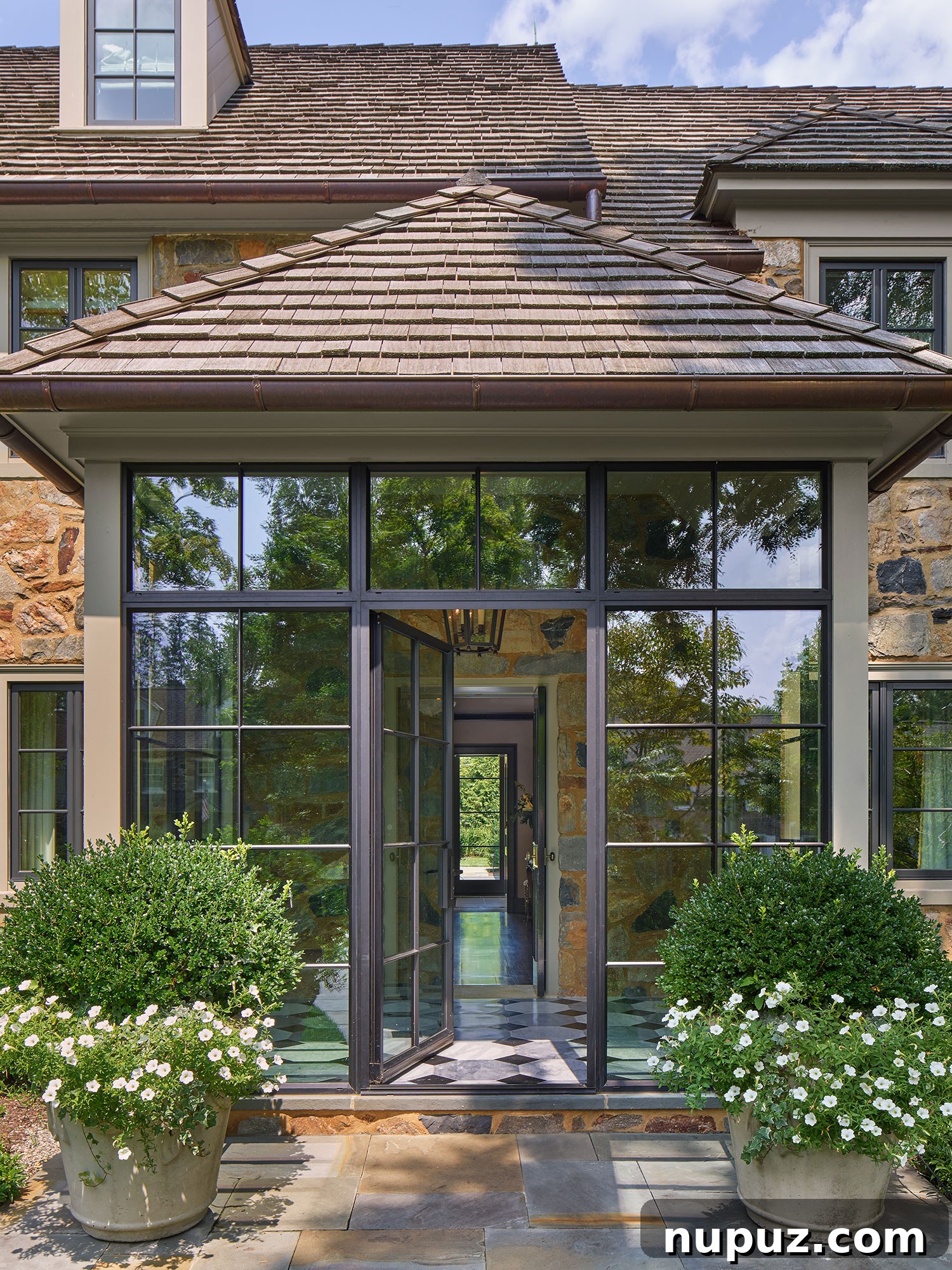 Beautiful welcome with this glass back entry to a stately stone home designed by Archer & Buchanan Architects, captured by Halkin | Mason Photography.