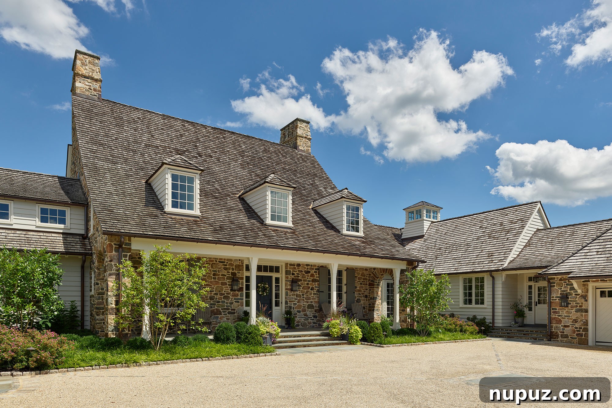 Architectural details of a home from Archer & Buchanan, featuring a majestic three-dormer stone home with matching stone fireplaces. Built by Cassella Builders, Inc., with Landscape Architecture by Stoney Bank Nurseries, and Photography by Jeffrey Totaro.
