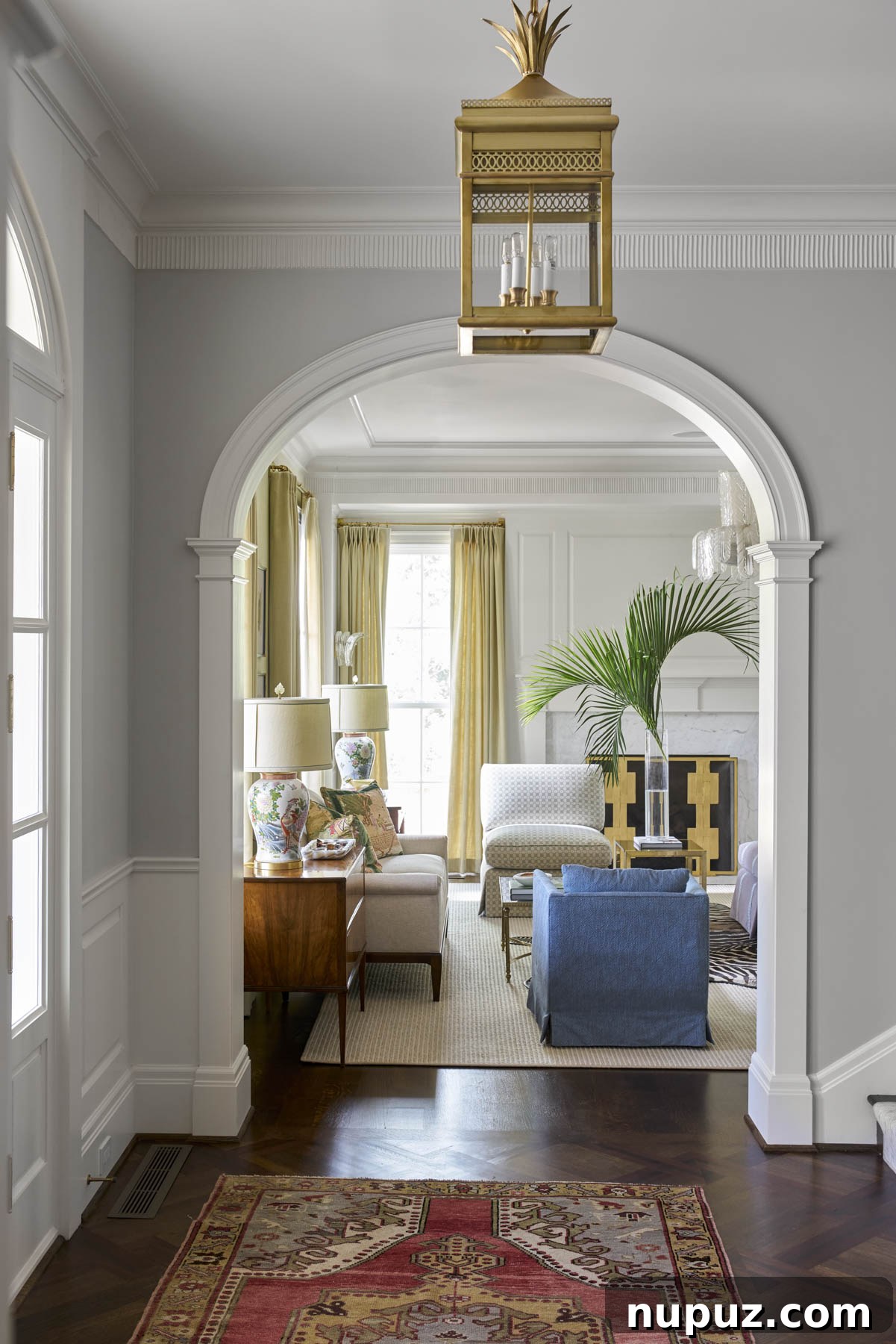 7 Entryway Transformations for an Impressive Welcome 6 Luxurious and spacious foyer showcasing a grand staircase, a large patterned rug, an ornate gilded mirror, and elegant furnishings, highlighting sophisticated living by Collins Interiors.