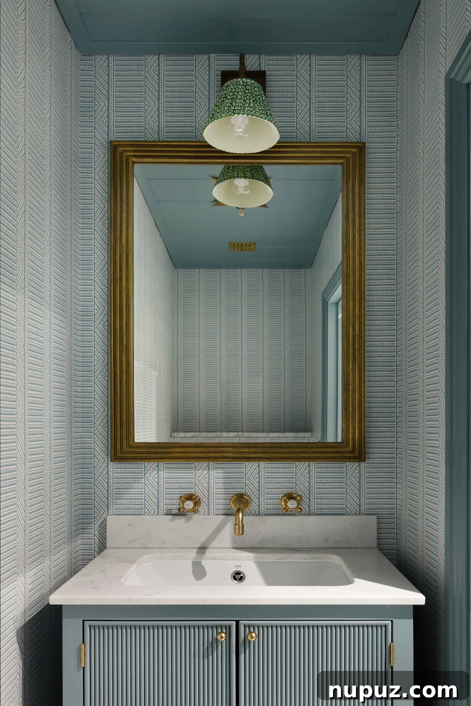 10 Steps to Your At-Home Spa Oasis 2 Luxurious spa-like bathroom with blue and white wallpaper, brass fixtures, and marble countertops, showcasing Hám Interiors design aesthetic by Alexander James Photography.
