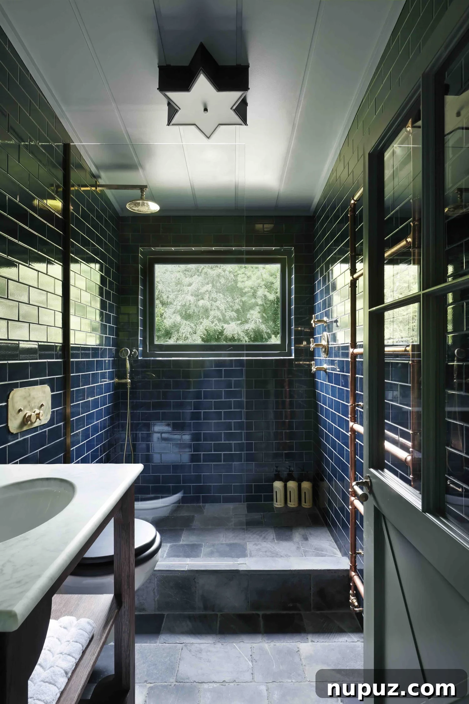 10 Steps to Your At-Home Spa Oasis 6 Stylish bathroom with exposed copper pipes contrasting beautifully with blue tiles and brass fixtures, showcasing a unique design from Hám Interiors by Alexander James Photography.