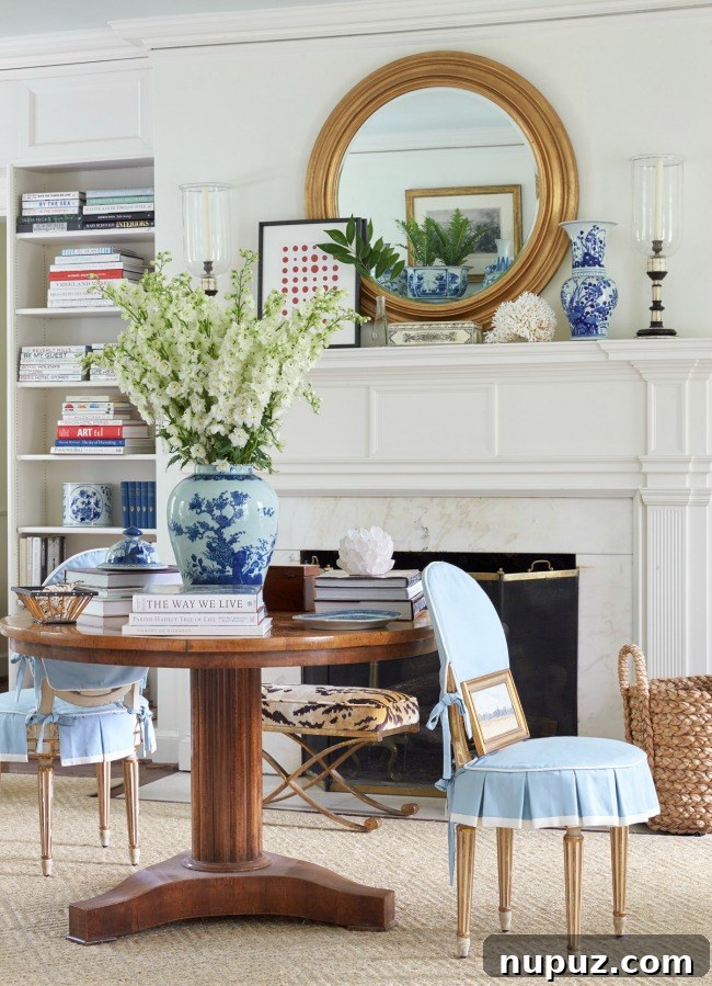 flowers on round table Sarah Bartholomew Interior Design with round mirror over mantell