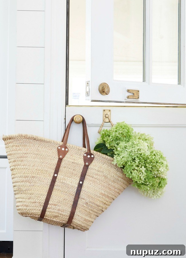 A charming Dutch door adorned with a beach bag filled with hydrangeas, showcasing Sarah Bartholomew's whimsical Southern style.