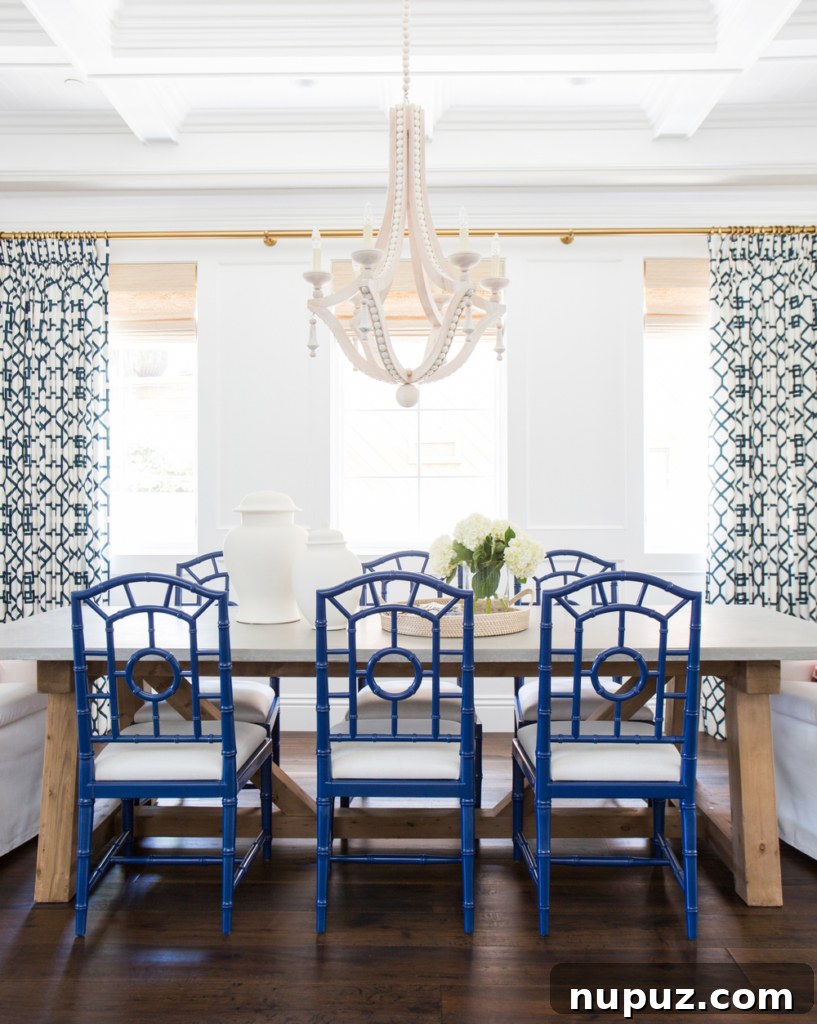 An elegant blue and white dining room designed by Studio McGee featuring intricate patterned wallpaper and classic furniture.