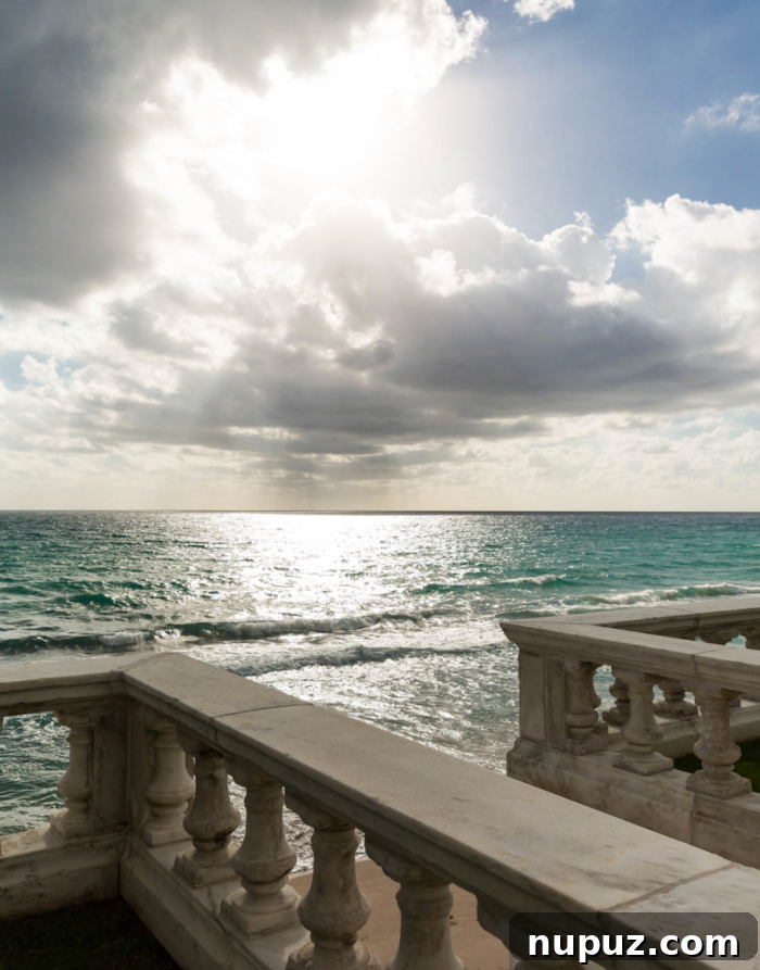 A breathtaking natural landscape of a pristine beach, with crystal blue water meeting white sand under a sky filled with soft white clouds, captured by Michael Stavaridis Photography.