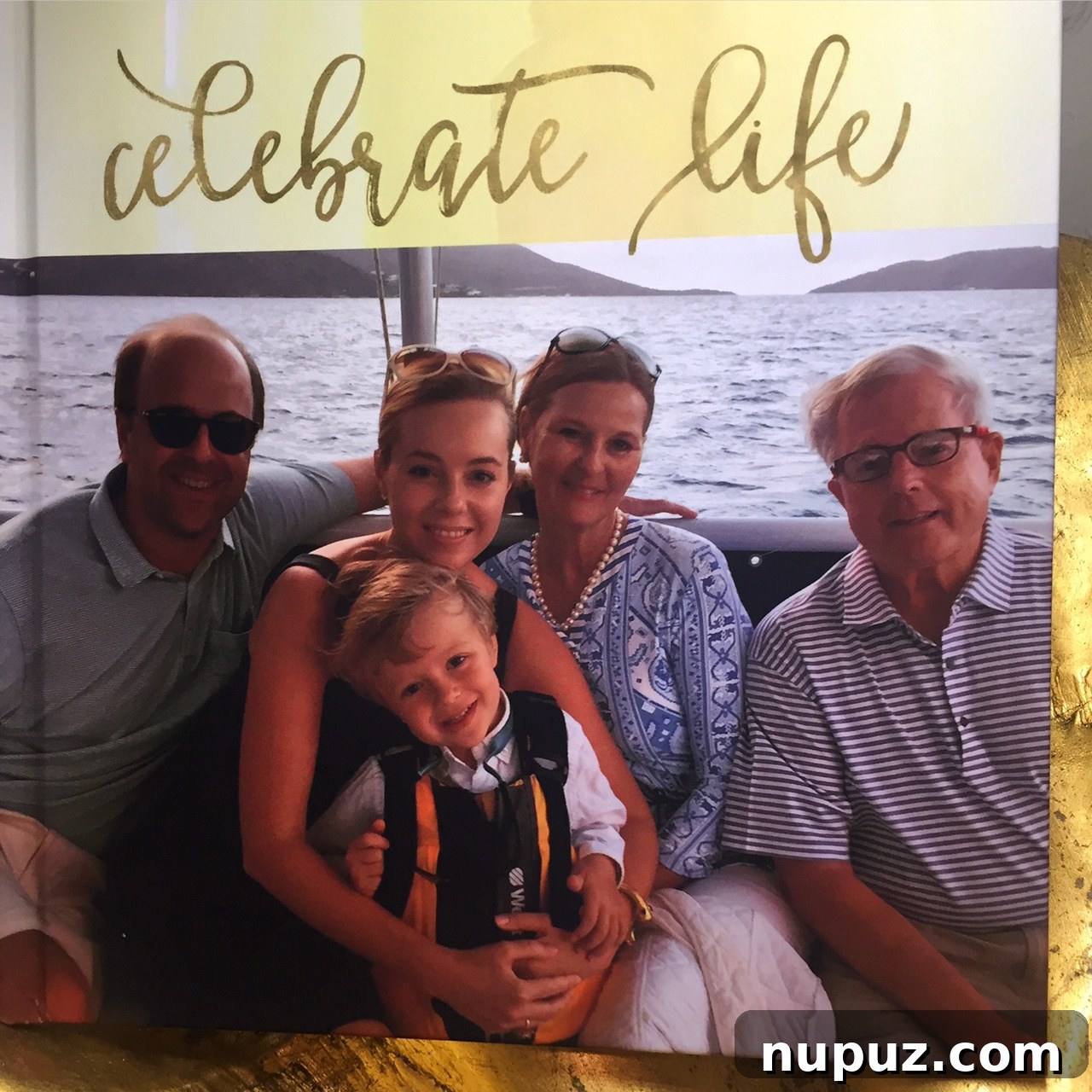 A beautifully designed Mixbook photo book featuring elegant gold accents and sophisticated calligraphy, open to a cherished family photograph