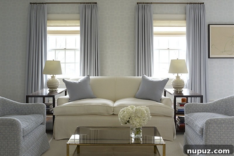 Serene master bedroom in blue and white, featuring a comfortable bed, elegant nightstands, and soft lighting.